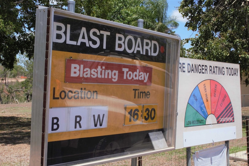 Mine blasting info board says 'blasting today', next to a fire danger rating board.