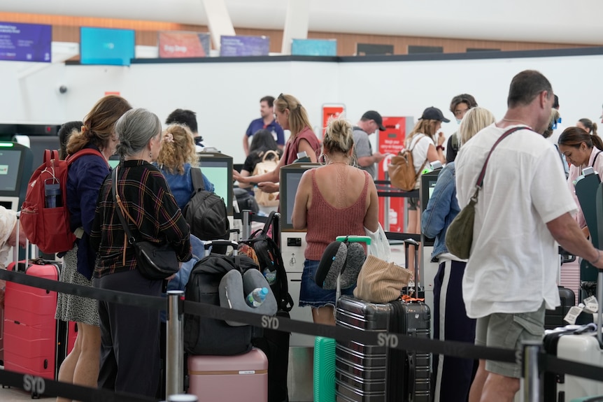 People lined up to check in at an airport.