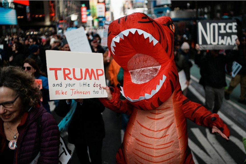 A man wearing an inflatable dinosaur costume.