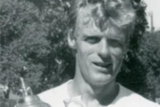 Black and white image of a man holding a sports trophy
