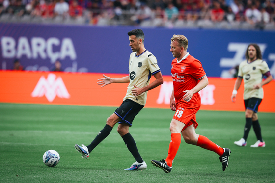 Barca Legends midfielder Sergio Busquets passes the ball as The Reds Legends winger Dirk Kuyt presses in the Champions Impact in Seoul 2026 match at Seoul World Cup Stadium in Mapo District, western Seoul, on June 6. [FC BARCELONA]