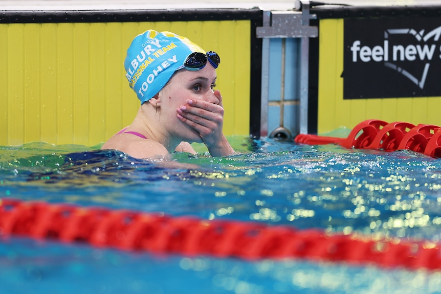 Sienna Toohey covers her mouth in the pool after a race.
