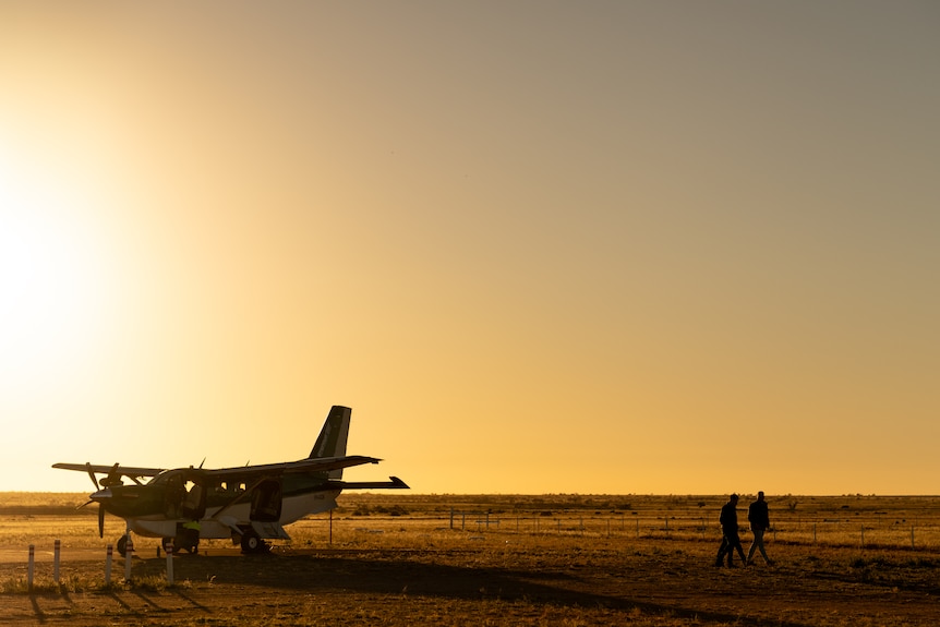 A sunset view of a small plane at a regional aerodrome.