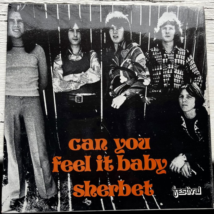 A black and white album cover with five men and orange writing saying "can you feel it baby, sherber".