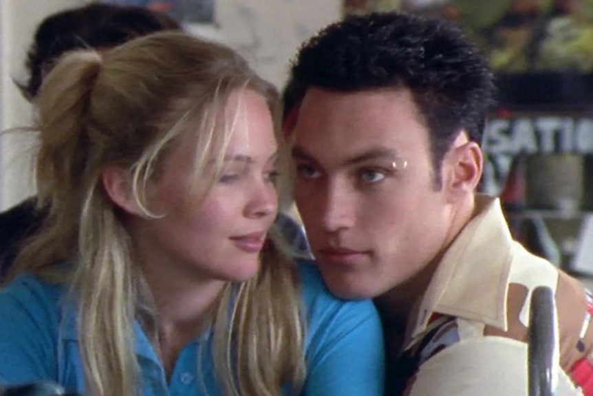 A close-up shot of a man and woman looking at each other intimately.
