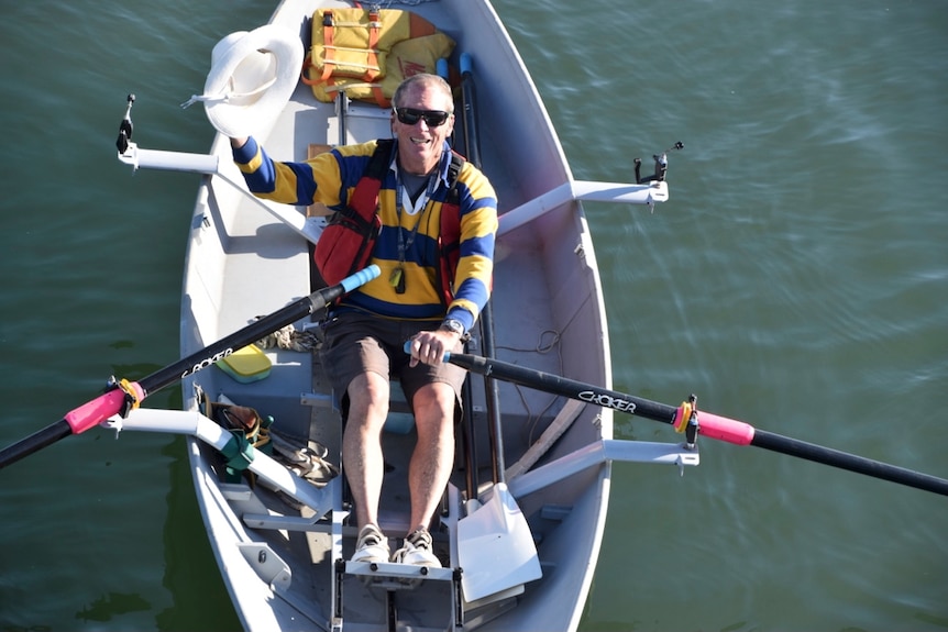 a man aged in his 70s rowing in a kayak.