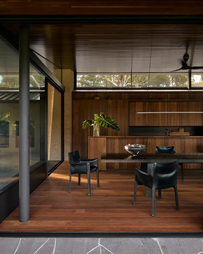 Views of modern timber-clad kitchen with black furniture