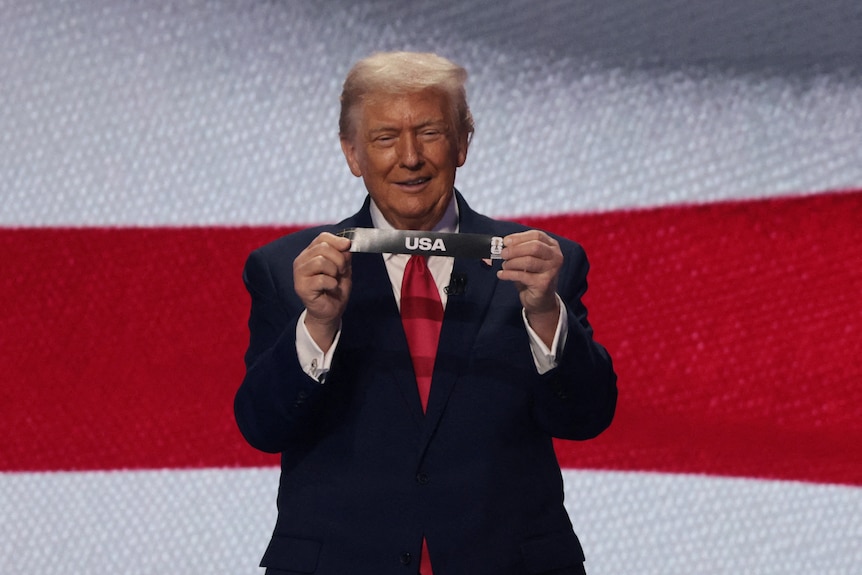 Donald Trump holds up the USA ticket in the draw for the World Cup