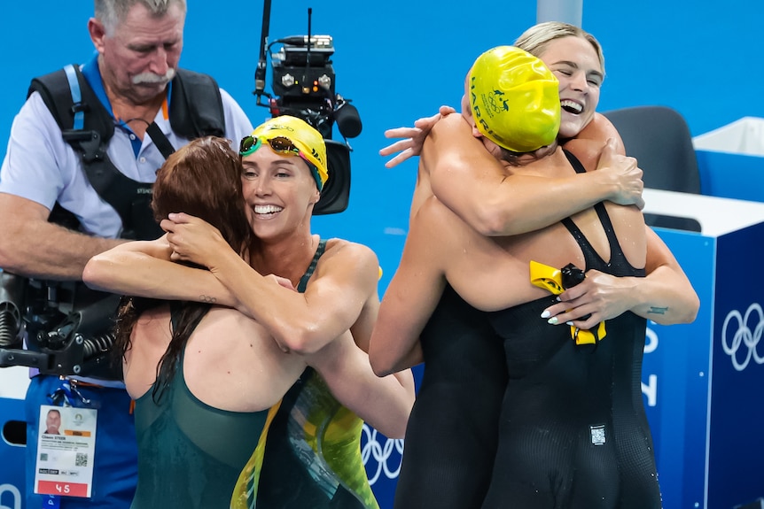 Mollie O'Callaghan, Shayna Jack, Emma McKeon and Meg Harris hug after winning the 4x100m freestyle relay at the Paris Olympics.