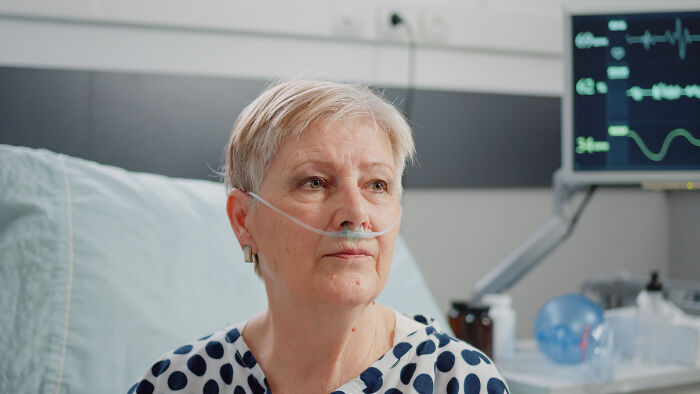 Elderly patient with a nasal cannula in a hospital bed, reflecting unexplained phenomena nurses encounter.
