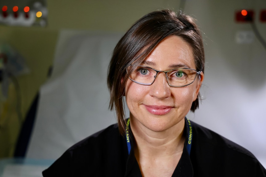 A woman with dark hair and glasses