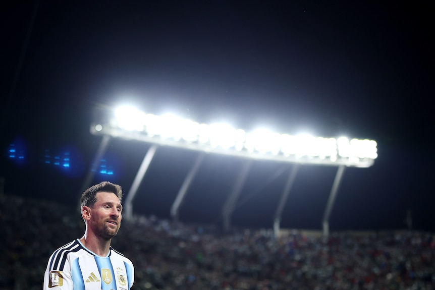 Lionel Messi with a floodlight behind him