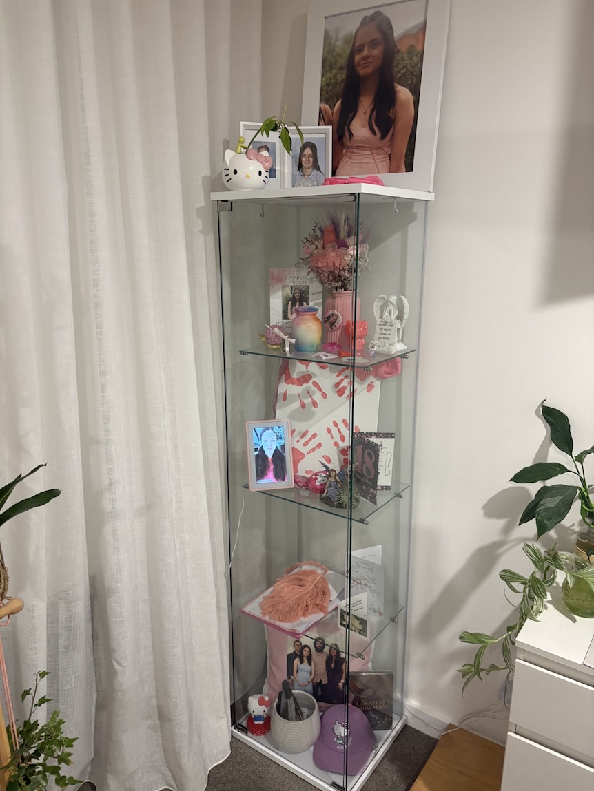 A shrine set up for Annalyse featuring photos, an 18th birthday card, artwork and keepsakes.