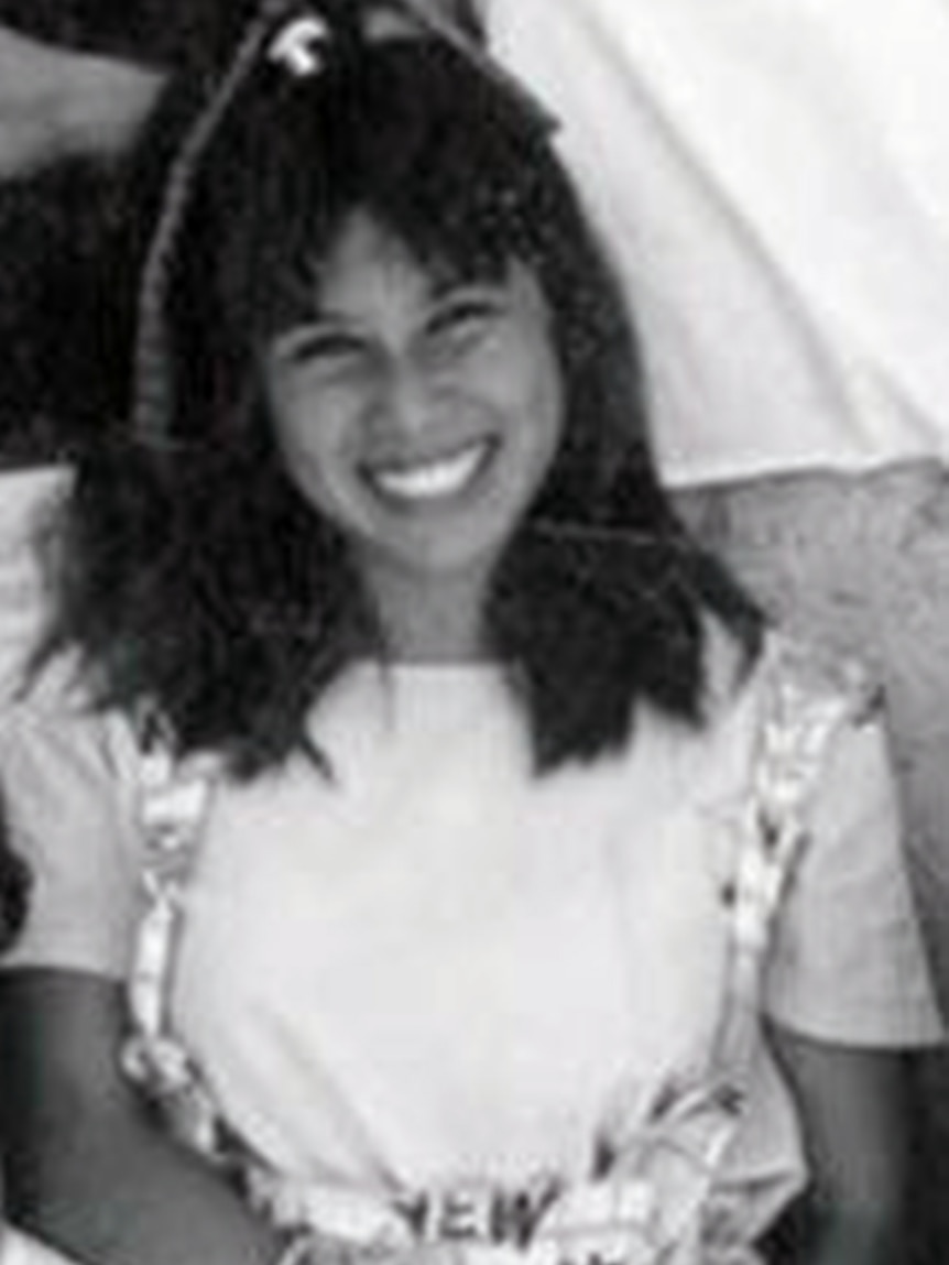 Black and white photo of a teenage girl in an 80s style outfit grinning broadly