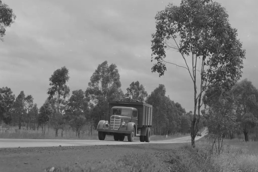 A black and white photo of a coal truck on a highway.