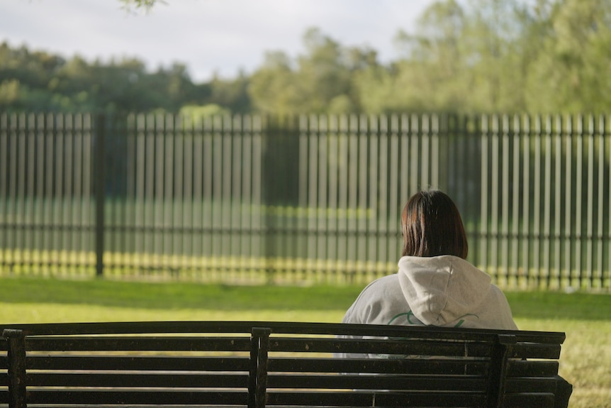 A woman sitting on a park bench.