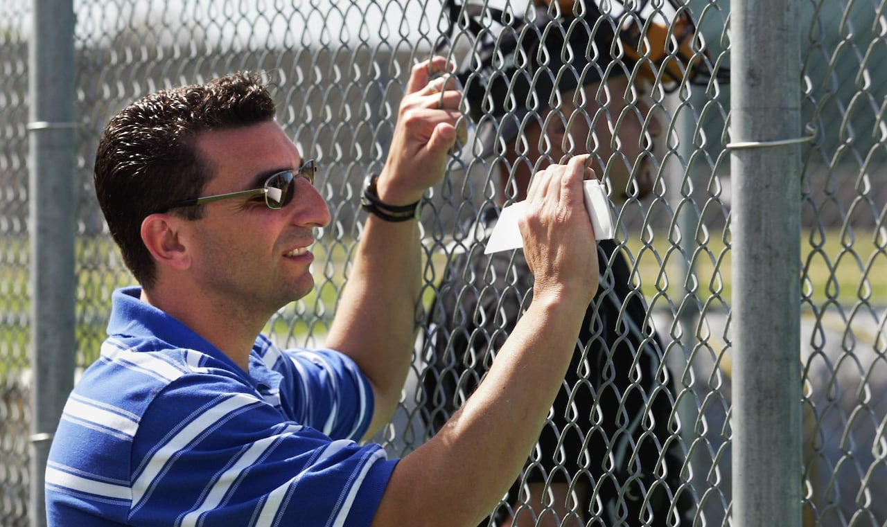 J.P. Ricciardi, holding onto a fence, while watching the action at spring training in Dunedin, Fla., in February 2004.