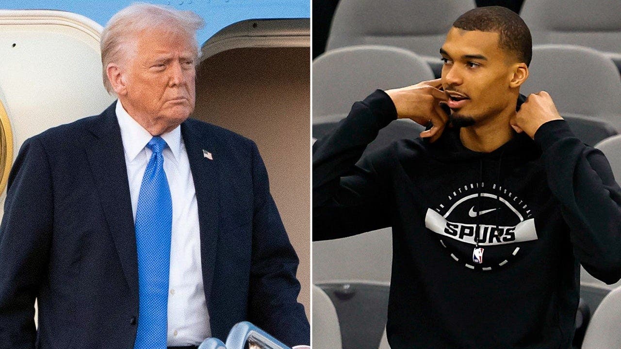 President Donald Trump reacts to Spurs star Victor Wembanyama folding his arms during the anthem