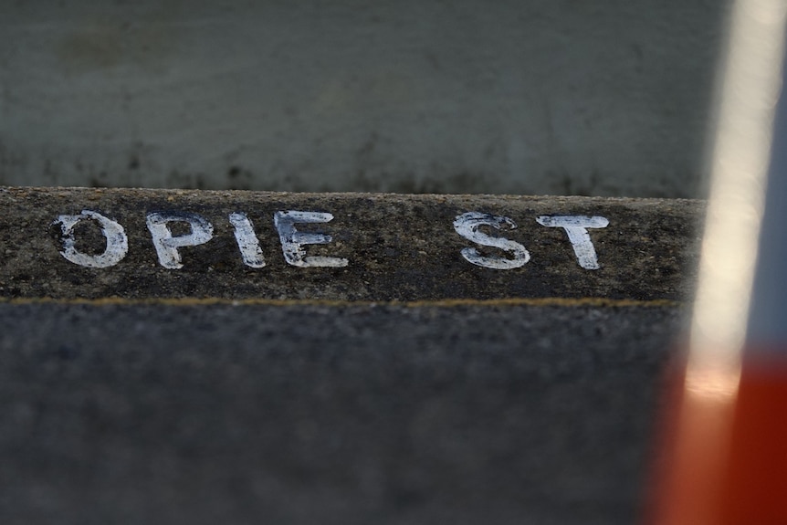 A photo of a road sign with opie street painted on it