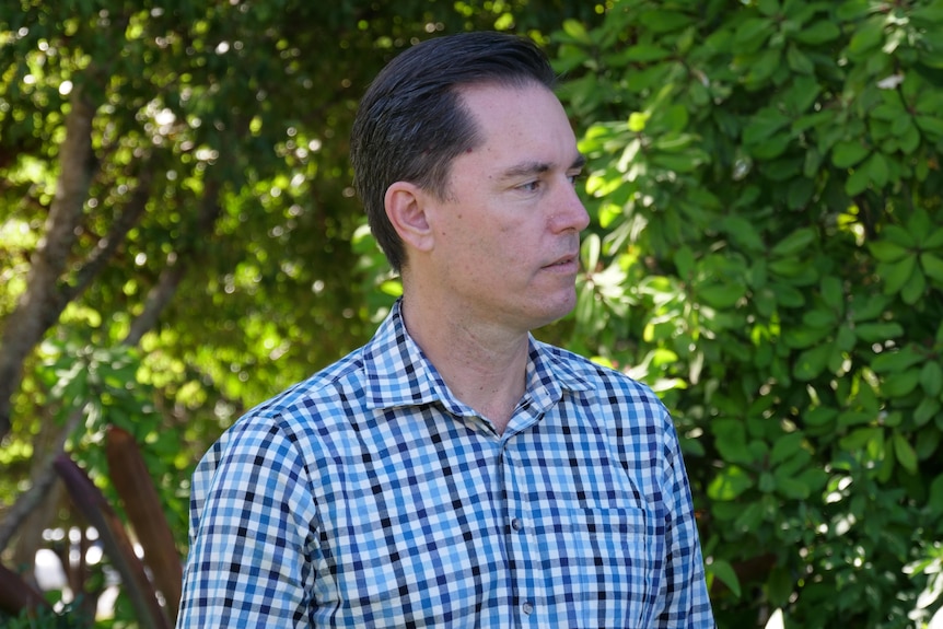 A man stares intently at a second person as they speak about a serious topic.