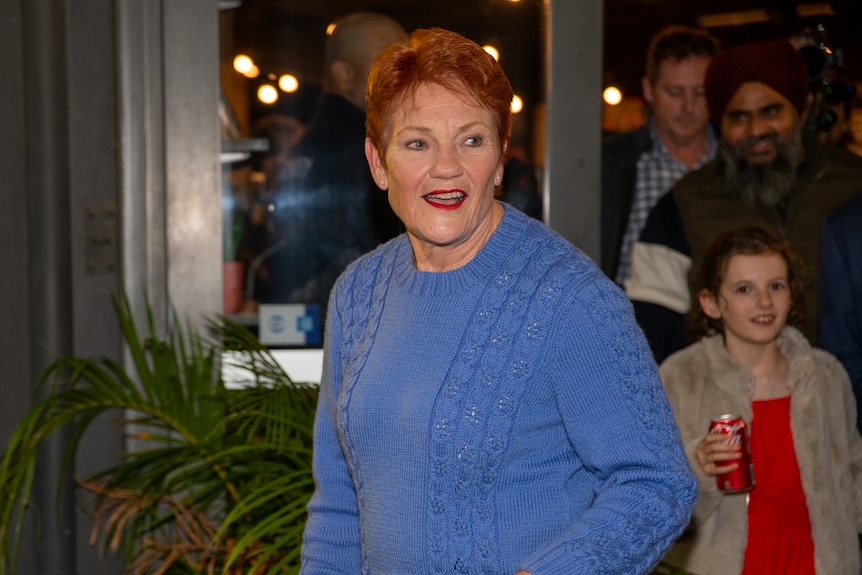 Pauline Hanson, wearing a blue top, looks to her left.