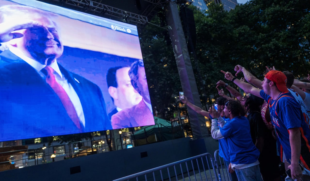 NEW YORK, NEW YORK - JUNE 8: People react as U.S. President Donald Trump appears on the screen during a watch party in Bryant Park for Game 3 of the NBA Finals between New York Knicks and San Antonio Spurs on June 8, 2026 in New York City. The New Yo