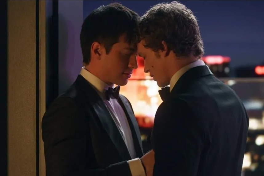 Two men in tuxedos with their foreheads touching.