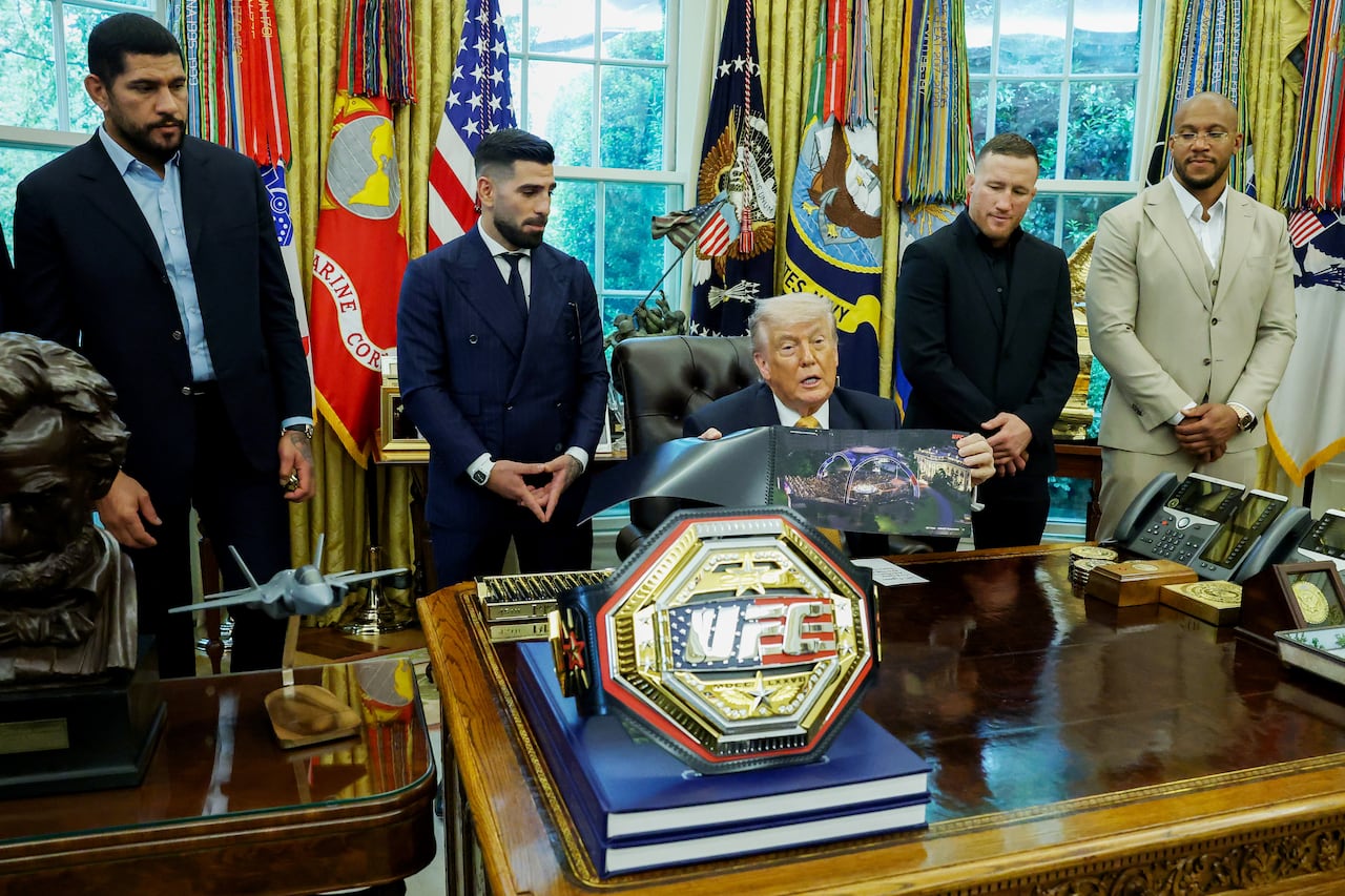 U.S. President Donald Trump presents his plans for his UFC Freedom 250 birthday event with some of the fighters standing behind him in the Oval Office.