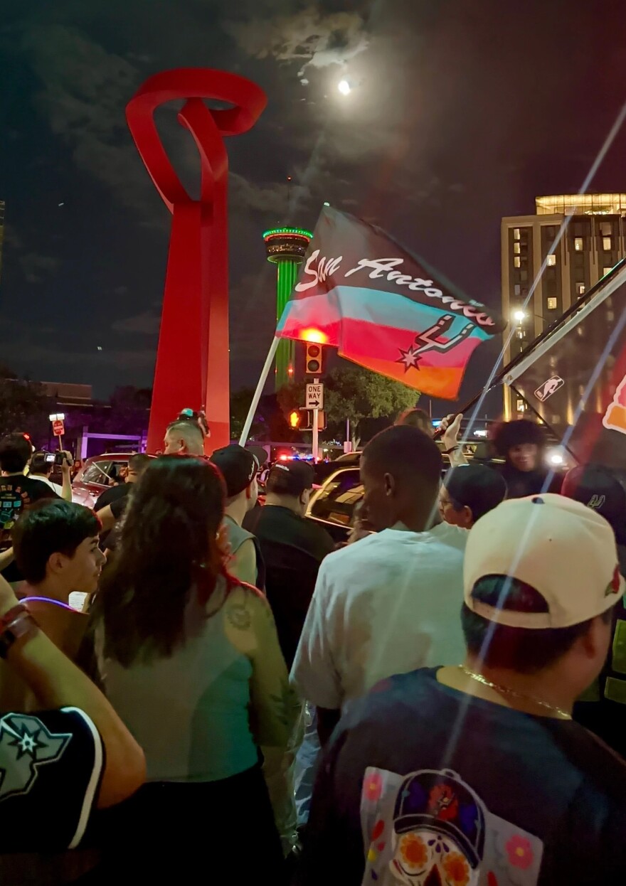 Spurs fans celebrate near the Torch of Friendship following the Spurs' Game 7 win over the Oklahoma City Thunder. As the playoff run continued, downtown San Antonio became a gathering place for fans celebrating a return to meaningful basketball in June.