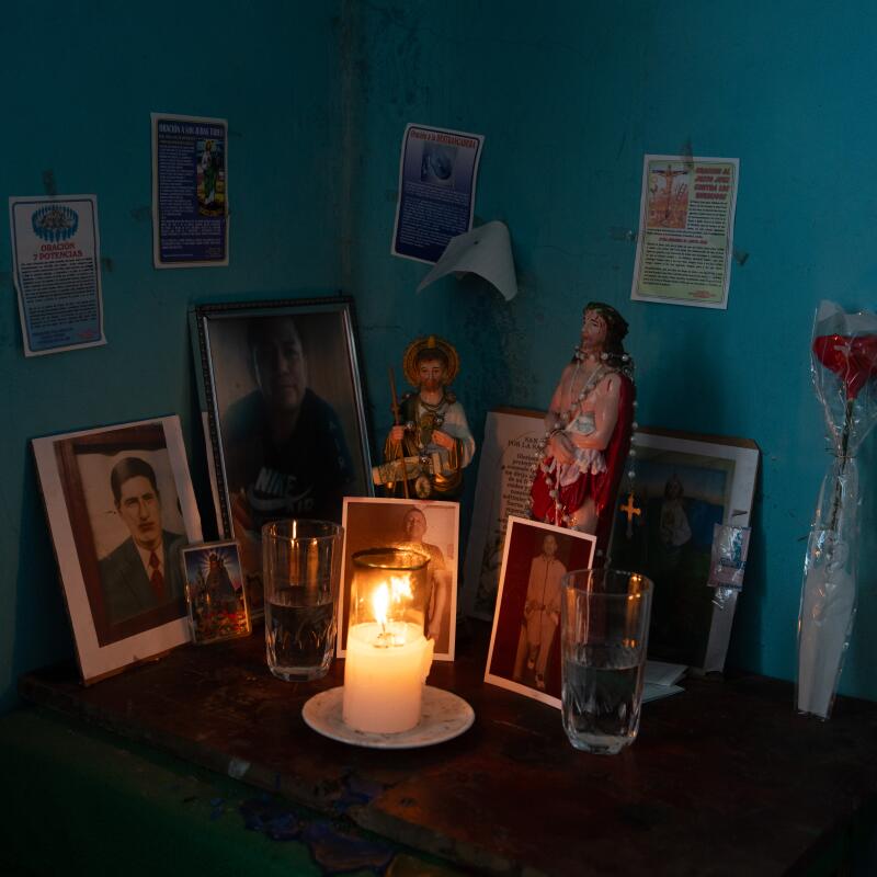 A candle burns in the altar created by Maria Cueva for her son