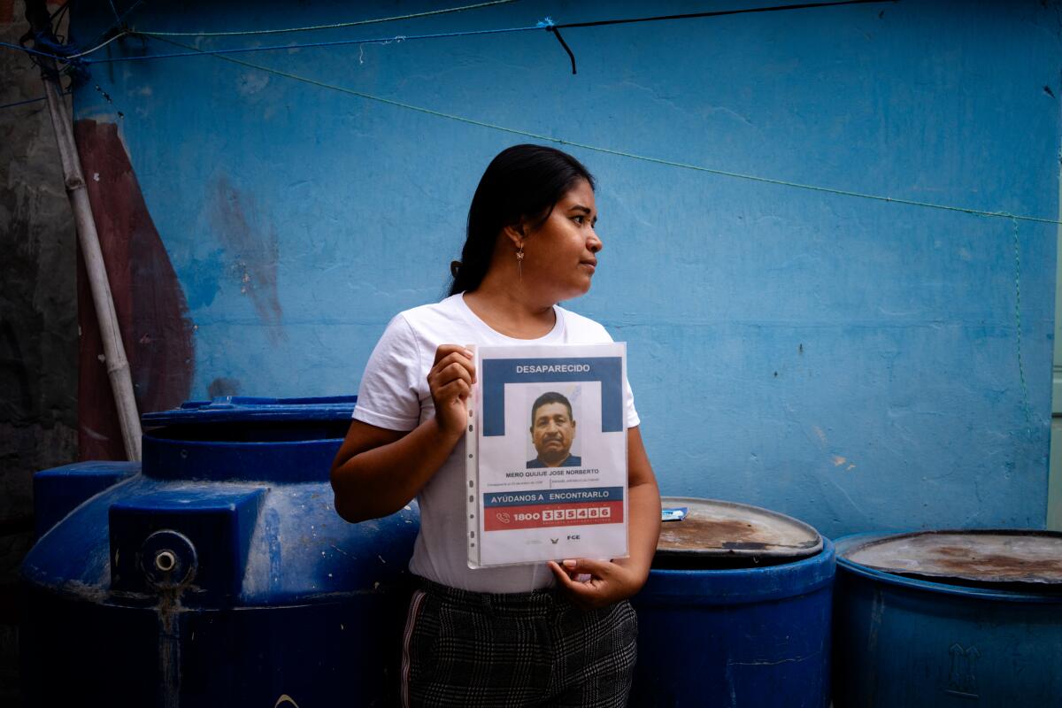 Wendy Dayana Mero Bailon, 27, holds a photograph of her father