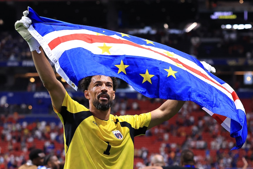 Vozinho celebrates by holding up a Cabo Verde flag
