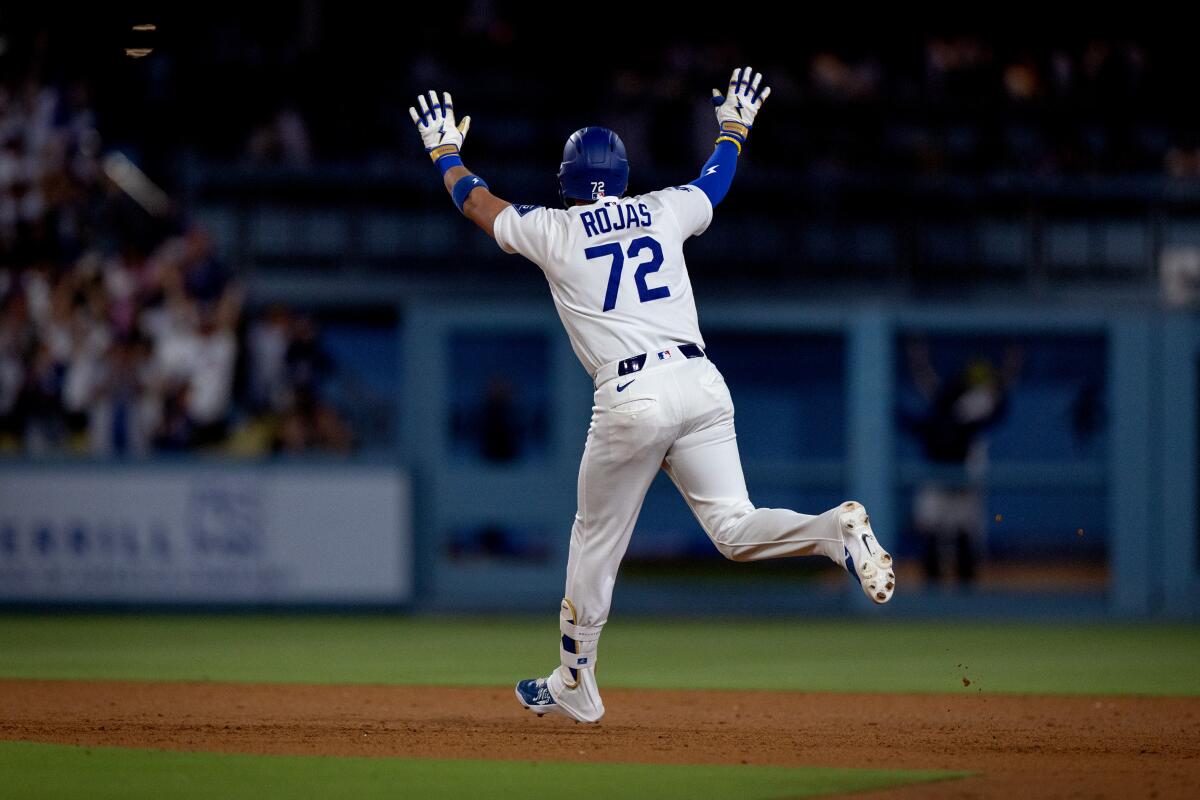 Miguel Rojas acknowledges the bullpen after homering in the seventh inning.