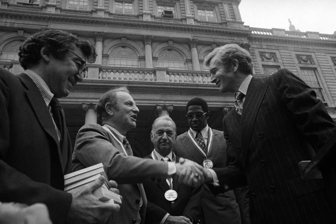 FILE - New York Mayor John Lindsay, right, congratulates Red Holzman, coach of the New York Knicks, after presenting the city's diamond jubilee medals to Holzman and other members of the Knicks team on the steps of City Hall on May 15, 1973. Shown with the mayor are Irving Felt, board chairman of Madison Square Garden, second from left, and Willis Reed, team captain, next to Lindsay.