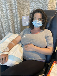 a masked pregnant woman doing chemotherapy