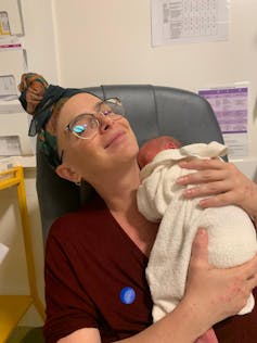smiling woman with baby in hospital