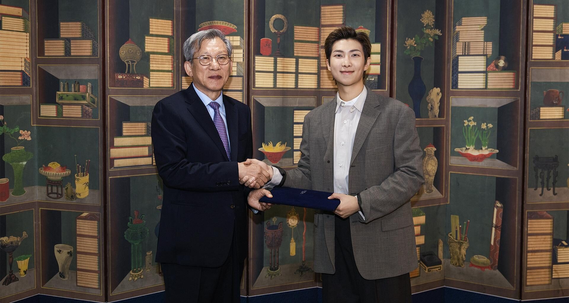 RM, right, the leader of K-pop supergroup BTS, shakes hands with You Hong-june, director of the National Museum of Korea, after being named global ambassador of the museum, in this photo provided by You