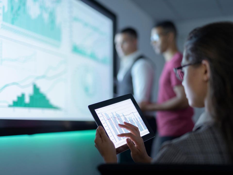 Businesswoman viewing graphs on digital tablet in business meeting