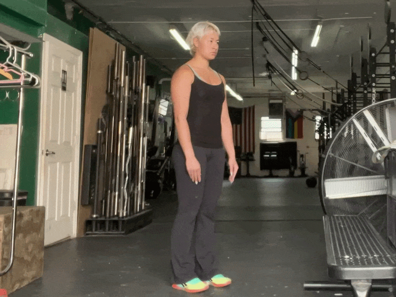 This is a photographic GIF demonstrating a heel raise exercise. In this exercise, stand with both feet shoulder-width apart. Raise your heels quickly, and then slowly lower them down onto the ground.