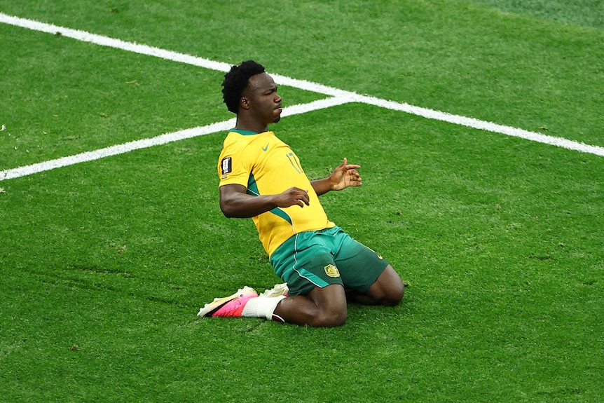 Irankunda slides along a green pitch on his knees.