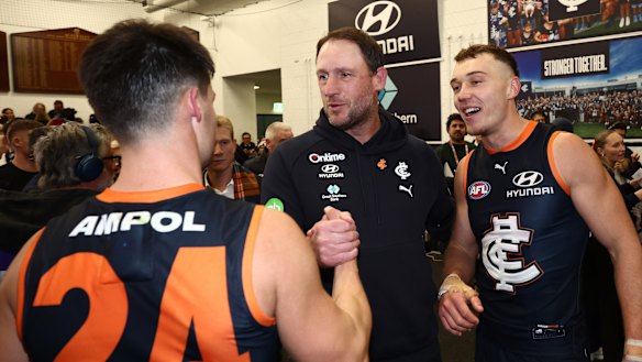 Nic Newman and Patrick Cripps congratulate Josh Fraser after a win.