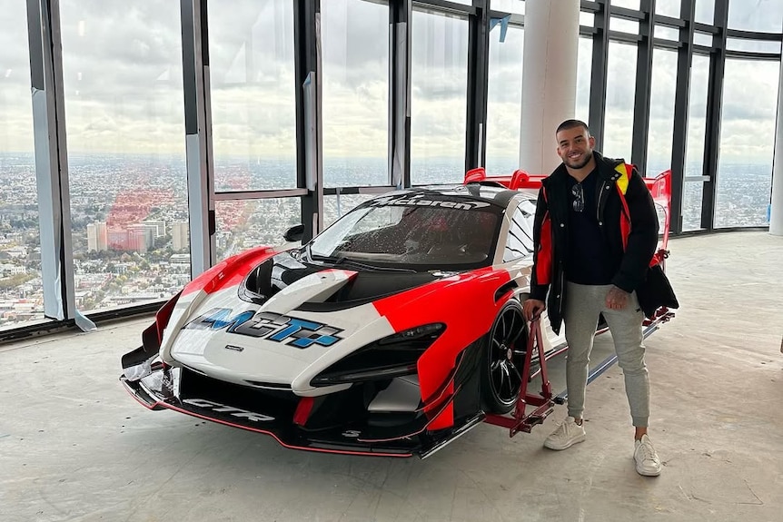 Man standing with luxury car inside penthouse