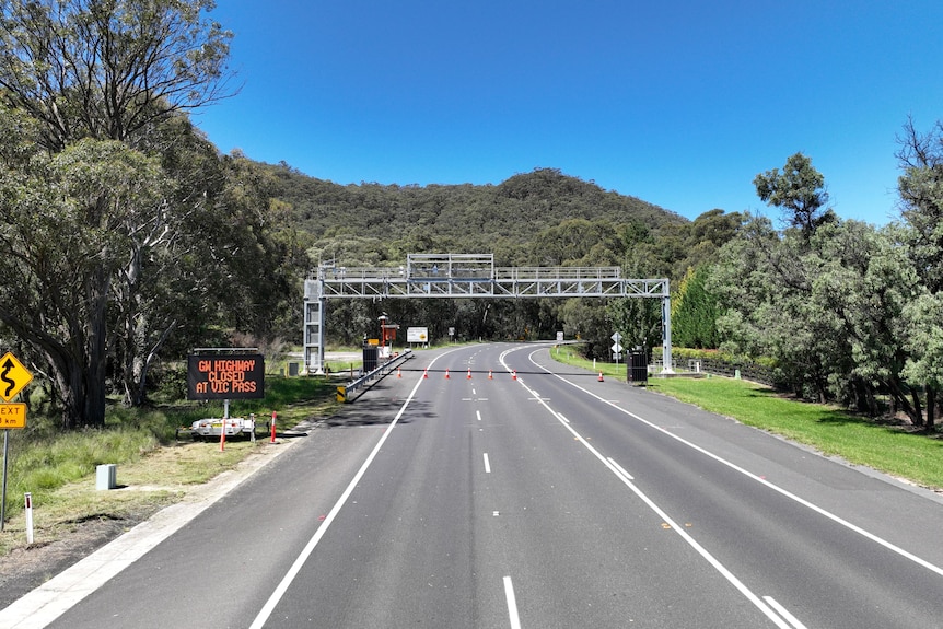 A picture of a road with no cars and closure signs
