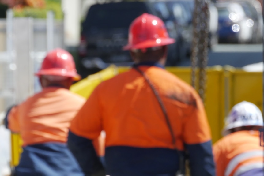 Construction workers at a Gold Coast worksite out of focus