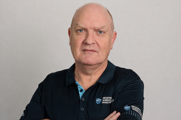A photo of a man with his arms crossed looking stern.