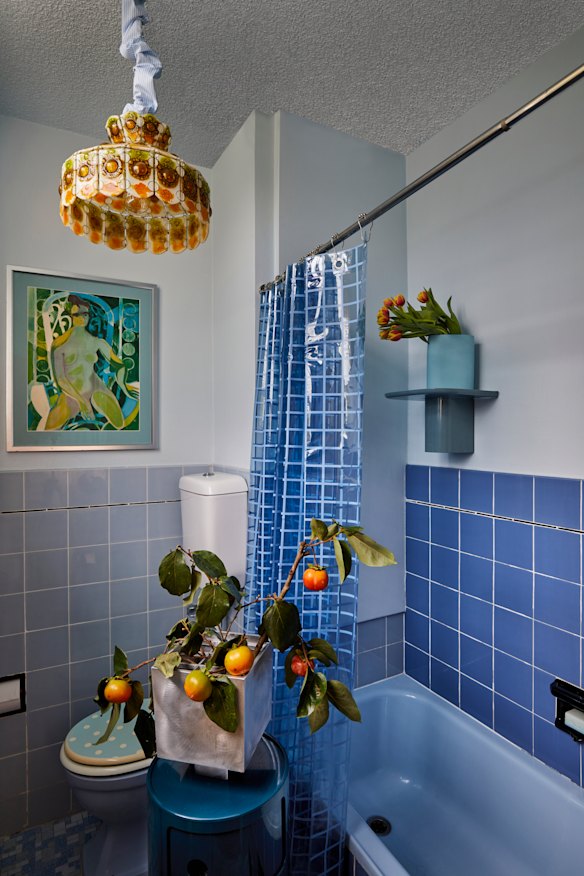 The bathroom is in its original blue. The “Componibili” storage unit is by Kartell, the “Ixia” vase by Hattie Molloy and the light by Felipe Derflingher for Feders.