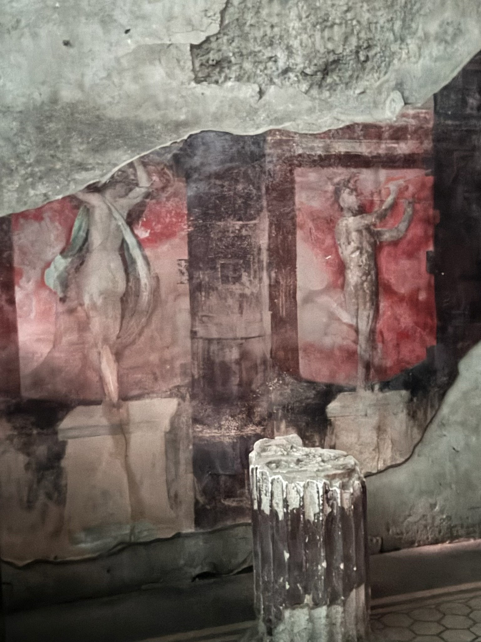 Picture of a Roman ruin showing painted fresco of a man and a woman on a red wall