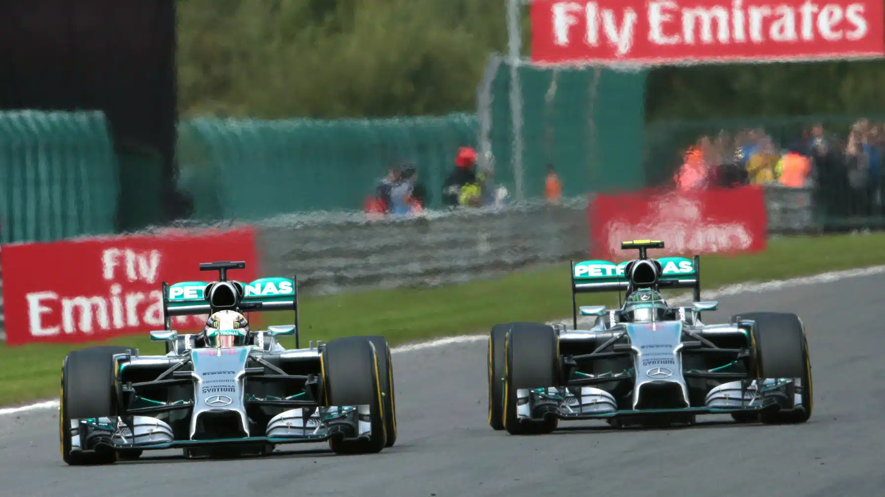 Mercedes drivers Lewis Hamilton and Nico Rosberg in a close fight on the first lap of the 2014 Belgian Grand Prix