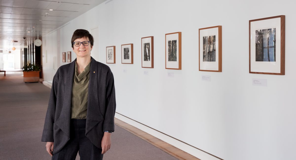 Woman in front of framed photos