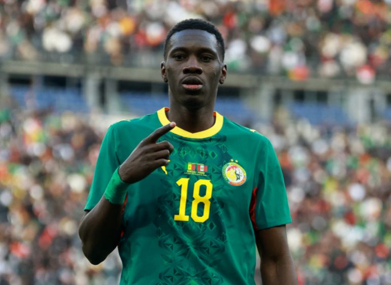 Sarr holds his finger out in celebration